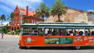 many people touring a big red trolley bus